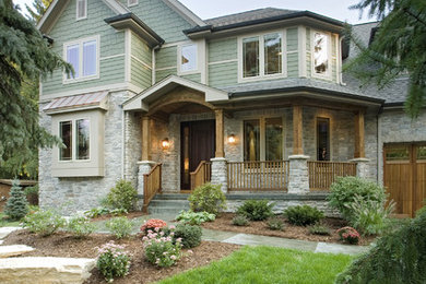 Large elegant green two-story wood exterior home photo in Chicago