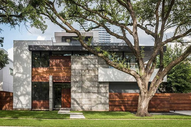 This is an example of a large and white modern house exterior in Houston with three floors, wood cladding and a flat roof.