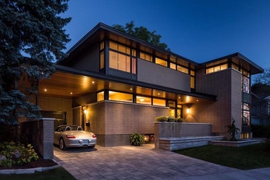 Inspiration for a large brown two-story brick flat roof remodel in Toronto