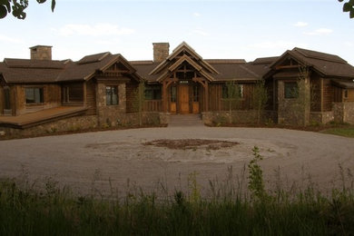 Cette image montre une grande façade de maison marron traditionnelle en bois à un étage avec un toit à deux pans.