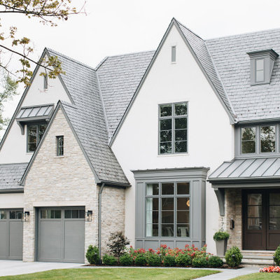 Large transitional white two-story stucco exterior home photo in Chicago