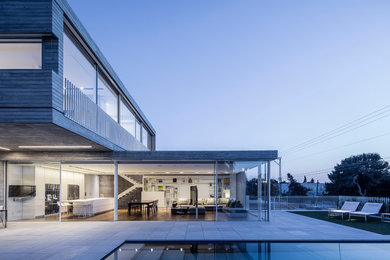 Ejemplo de fachada de casa gris moderna de dos plantas con revestimiento de hormigón y tejado plano