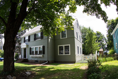 Example of a mid-sized classic green two-story wood exterior home design in Boston with a shingle roof