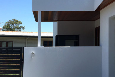 This is an example of a gey modern concrete house exterior in Brisbane with a flat roof.