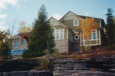 Foto de fachada verde clásica de tamaño medio de dos plantas con revestimiento de madera y tejado a dos aguas