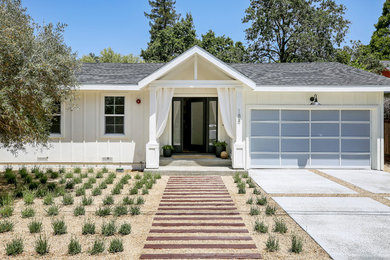 Réalisation d'une façade de maison blanche champêtre en bois de taille moyenne et de plain-pied avec un toit à deux pans et un toit en shingle.