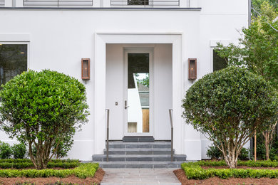 Mid-sized modern white two-story stucco house exterior idea in New Orleans with a metal roof