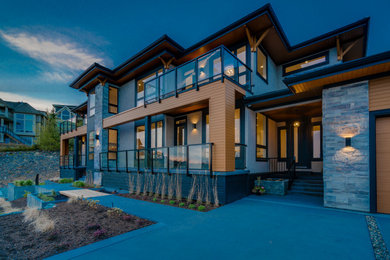 Inspiration for a large contemporary brown three-story stucco exterior home remodel in Vancouver with a tile roof
