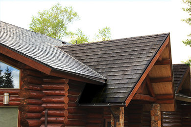 Ejemplo de fachada de casa marrón rural grande de dos plantas con revestimientos combinados, tejado a cuatro aguas y tejado de teja de barro