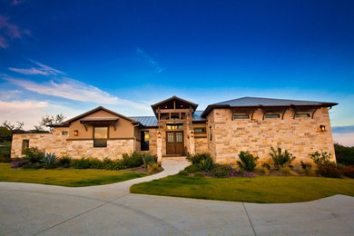 Large rustic brown one-story stone exterior home idea in Austin with a hip roof