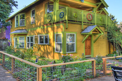 Example of a mid-sized eclectic yellow two-story wood exterior home design in Other