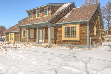 This is an example of a medium sized classic two floor house exterior in Grand Rapids with wood cladding.