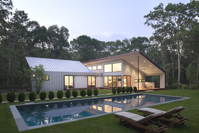 Inspiration for a mid-sized contemporary beige one-story metal exterior home remodel in New York with a shed roof