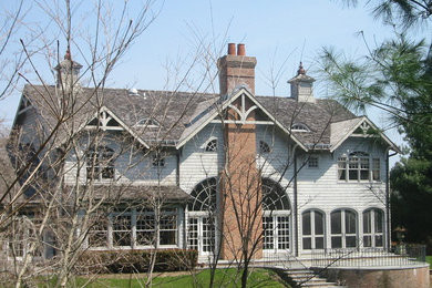 Diseño de fachada gris de estilo americano grande de dos plantas con revestimiento de madera