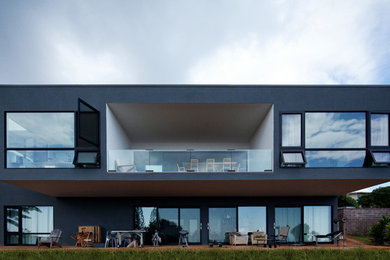 Idee per la facciata di una casa grigia moderna a due piani di medie dimensioni con rivestimento in stucco