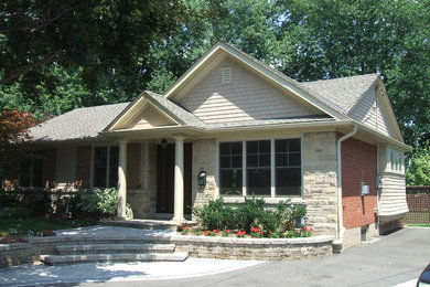 Imagen de fachada de casa multicolor clásica de tamaño medio de una planta con revestimiento de metal, tejado a cuatro aguas y tejado de teja de madera