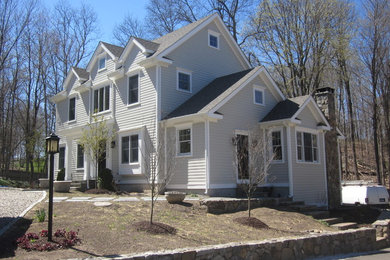 Example of a large classic gray three-story concrete fiberboard gable roof design in New York