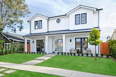 Inspiration for a large coastal white two-story wood house exterior remodel in Orange County with a mixed material roof