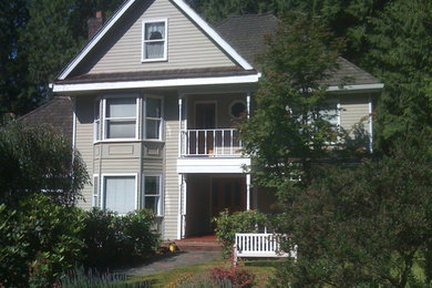Example of a mid-sized classic beige three-story wood exterior home design in Seattle with a hip roof
