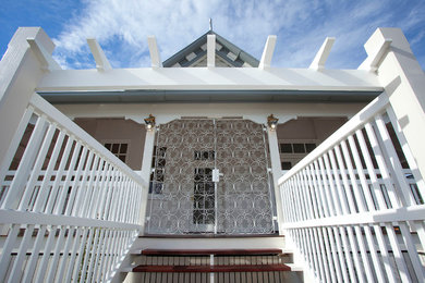 Modelo de fachada blanca clásica grande de dos plantas con revestimiento de madera y tejado a cuatro aguas