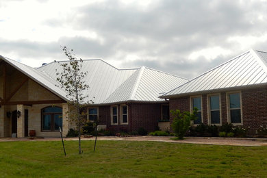 Example of a large eclectic one-story stone exterior home design in Austin with a hip roof