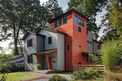 Imagen de fachada gris contemporánea de tamaño medio de tres plantas con revestimiento de aglomerado de cemento y tejado a doble faldón
