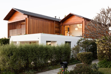 Photo of a contemporary two floor detached house in Sydney with stone cladding.