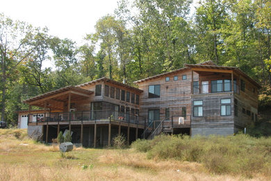 Diseño de fachada de casa marrón actual grande de tres plantas con revestimiento de madera