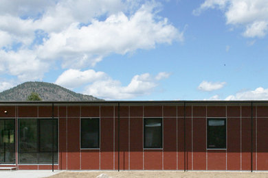 Diseño de fachada roja contemporánea pequeña de una planta con revestimiento de aglomerado de cemento