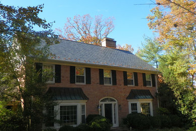Modelo de fachada de casa roja tradicional grande de dos plantas con revestimiento de ladrillo, tejado a dos aguas y tejado de teja de madera