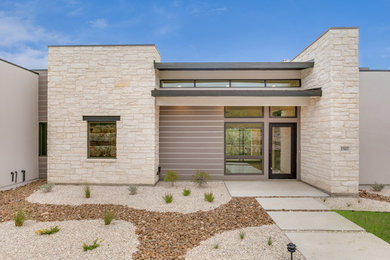 Ispirazione per la facciata di una casa beige contemporanea a un piano di medie dimensioni con rivestimento in pietra e tetto piano