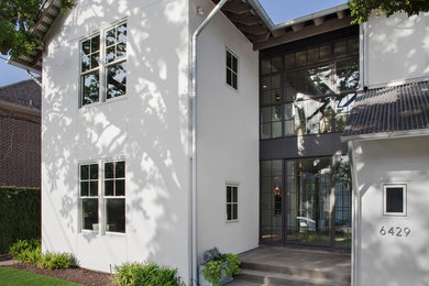Example of a large transitional white two-story stucco exterior home design in Houston with a metal roof