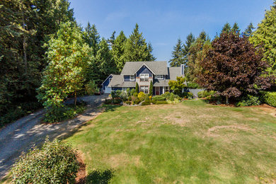 Inspiration for a large timeless blue two-story wood exterior home remodel in Seattle with a clipped gable roof