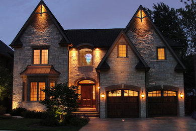 Inspiration for a large and beige traditional two floor house exterior in Chicago with stone cladding and a pitched roof.