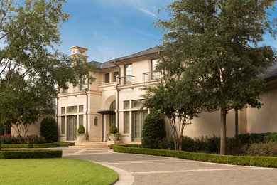 Large minimalist beige two-story stucco exterior home photo in Dallas with a shingle roof