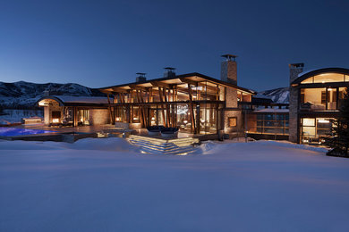 Example of a huge mountain style house exterior design in Denver