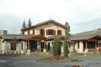 Mid-sized tuscan beige two-story mixed siding exterior home photo in Other with a clipped gable roof