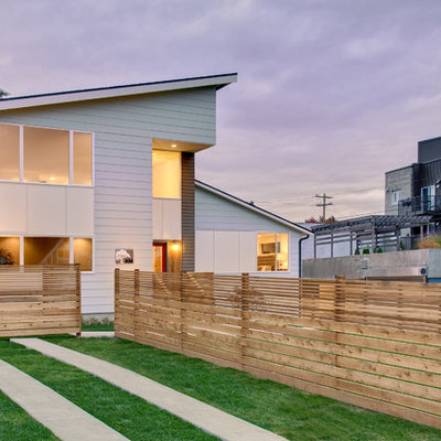 Example of a trendy white two-story exterior home design in Seattle with a shed roof