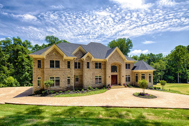 Huge elegant beige two-story brick exterior home photo in DC Metro with a shingle roof