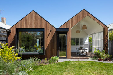 Modelo de fachada de casa marrón contemporánea de tamaño medio de una planta con revestimiento de madera, tejado a dos aguas y tejado de metal
