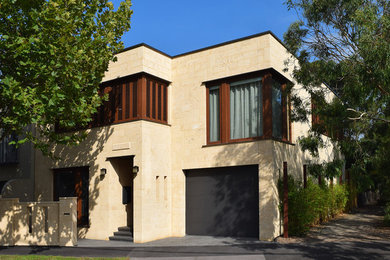 Modelo de fachada beige contemporánea de tamaño medio de dos plantas con revestimiento de piedra y tejado plano