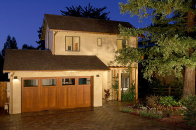 Idée de décoration pour une façade de maison beige design en stuc de taille moyenne et à un étage avec un toit à deux pans.