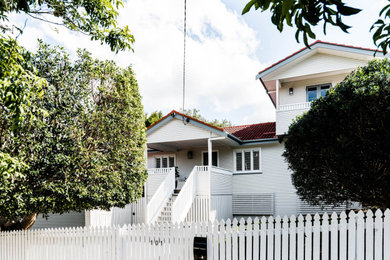 Mid-sized danish white three-story wood exterior home photo in Brisbane with a tile roof