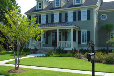 Imagen de fachada de casa verde retro de tamaño medio de dos plantas con revestimiento de vinilo, tejado a dos aguas y tejado de teja de madera