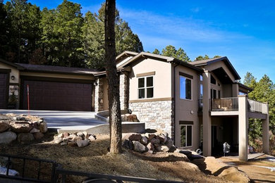 Inspiration for a timeless brown stucco gable roof remodel in Denver