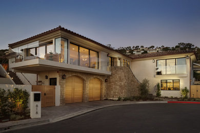 Large cottage beige two-story stucco house exterior photo in Orange County with a tile roof