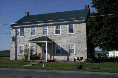 Imagen de fachada de casa gris de estilo de casa de campo de tamaño medio de dos plantas con revestimiento de piedra, tejado a dos aguas y tejado de teja de madera