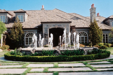Example of a large transitional two-story stone gable roof design in Los Angeles