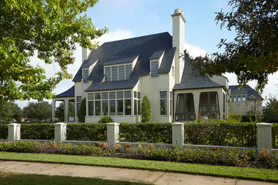 Foto della villa grande beige classica a due piani con rivestimento in mattoni, tetto a padiglione e copertura in tegole