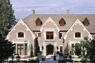 Example of a large classic brown three-story brick exterior home design in Seattle